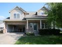 Two-story home showcasing a mix of brick and siding, an attached garage, and a cozy front porch with manicured landscaping at 10949 Haig Point Dr, Fishers, IN 46037