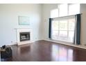 Bright living room features a fireplace, large windows with curtains, and gleaming hardwood floors at 10949 Haig Point Dr, Fishers, IN 46037