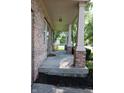 Inviting front porch with brick columns, offering a comfortable and shaded outdoor space with view of front yard at 10949 Haig Point Dr, Fishers, IN 46037