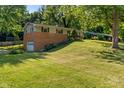 Inviting split-level home with a garage and lush greenery at 1302 N Furman Ave, Indianapolis, IN 46214