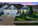 Charming home with a well-manicured lawn, two-car garage, and stylish architectural details at dusk at 16235 Natures Way, Westfield, IN 46074
