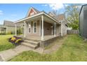Inviting home showcasing a large front porch, neat landscaping, and a cozy, welcoming facade at 2026 E 10Th St, Indianapolis, IN 46201