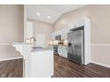 Modern kitchen featuring stainless steel appliances, white cabinets, granite countertops and luxury vinyl plank flooring at 216 Haywood Rd, Greenwood, IN 46142