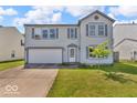 Two-story home with a white two car garage door, complemented by a front yard tree at 2309 Westmere Dr, Plainfield, IN 46168