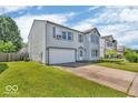 Two-story home featuring an attached two-car garage, a cozy front porch and green lawn at 2309 Westmere Dr, Plainfield, IN 46168
