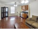 Open-concept living room with hardwood floors, bar with wine rack and refrigerator at 2355 Collins Way, Greenfield, IN 46140