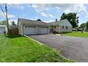 View of the home and the attached two car garage with a paved driveway and well maintained lawn at 3059 Tansel Rd, Indianapolis, IN 46234