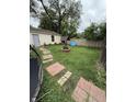 Well-maintained backyard featuring green lawn, a charming fire pit, and partial fencing at 3301 S Lockburn St, Indianapolis, IN 46221