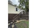 Charming home exterior featuring a wooden deck, stairs, and decorative flower garden at 3301 S Lockburn St, Indianapolis, IN 46221