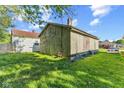 View of the rear exterior of this home showing overgrown lawn and exterior wood at 3335 W 9Th St, Indianapolis, IN 46222