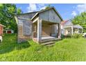This property needs work, including overgrown grass and boarded-up windows at 3335 W 9Th St, Indianapolis, IN 46222