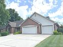 Spacious three-car garage with a large driveway and attractive brick exterior at 3975 Keyway Dr, Greenwood, IN 46143