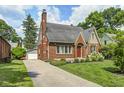 Beautiful brick home with a well-kept lawn, long driveway and detached garage at 5430 N Kenwood Ave, Indianapolis, IN 46208