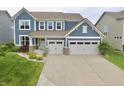 Stylish two-story home with light blue siding, a two-car garage and a well-manicured lawn at 5473 Forest Glen Dr, Brownsburg, IN 46112