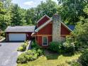 Charming two-story home with a stone chimney, attached garage, and professionally landscaped yard at 5631 Shelby St, Indianapolis, IN 46227