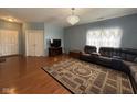 Cozy living room featuring wood floors, a chandelier, and comfortable seating at 621 Appleseed Way, Indianapolis, IN 46217