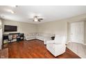 Cozy living room featuring wood floors, a ceiling fan, comfortable seating, and a TV at 6562 Quail Run, Fishers, IN 46038
