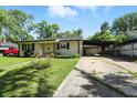 Exterior view showcasing the single-story home with covered parking and a well-kept front lawn at 7307 Twin Beech Dr, Indianapolis, IN 46226