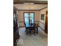 Formal dining room features classic chandelier, light walls, carpet and dark wood trim at 7334 Fairwood Cir, Indianapolis, IN 46256
