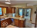 Warm, inviting kitchen offers granite counters, wood cabinetry, stainless dishwasher and eat-in space at 7334 Fairwood Cir, Indianapolis, IN 46256