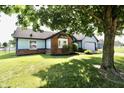 Charming, single-story home with blue siding, brick accents, well-maintained landscaping, and an attached garage at 7567 Muirfield Pl, Indianapolis, IN 46237