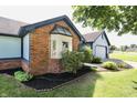 Charming, single-story home with blue siding, brick accents, well-maintained landscaping, and an attached garage at 7567 Muirfield Pl, Indianapolis, IN 46237