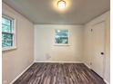 Bright bedroom featuring wood-look floors, two windows, and a closet, offering a serene retreat at 7719 Grandview Dr, Indianapolis, IN 46260