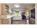 Modern kitchen with stainless steel appliances, gray cabinets, subway tile backsplash, and wood-look floors at 7719 Grandview Dr, Indianapolis, IN 46260