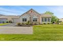 Charming home featuring a stone facade, arched windows, and meticulously maintained landscaping at 7850 King Post Dr, Indianapolis, IN 46237