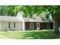 Charming tan and brown house with well-maintained lawn and mature trees in a quiet, residential neighborhood at 7966 Chiltern Dr, Indianapolis, IN 46268