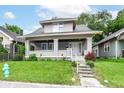 Charming two-story home featuring a classic front porch with brick supports and a well-maintained lawn at 806 N Gray St, Indianapolis, IN 46201
