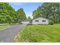 Well-maintained white brick ranch-style home with attached garage, long black driveway, and landscaped front yard at 8105 Allisonville Rd, Indianapolis, IN 46250