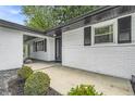 Inviting covered entrance with white brick, black trim, a freshly landscaped front yard and upgraded front door at 8105 Allisonville Rd, Indianapolis, IN 46250