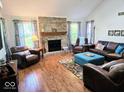 Spacious living room featuring a brick fireplace, hardwood floors, and ample natural light from large windows at 8394 Glen Highlands Dr, Indianapolis, IN 46236