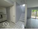 Bright entryway with tile flooring, stairs, and sliding door leading to the backyard at 9458 Fordham St, Indianapolis, IN 46268