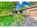 Inviting home exterior featuring a beautifully landscaped front yard with colorful flowers and a covered entryway at 11 N Restin Rd, Greenwood, IN 46142
