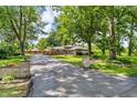Charming home with mature trees, long driveway, and a stone wall entrance at 1340 Eustis Dr, Indianapolis, IN 46229