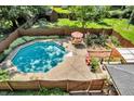 Aerial view of a backyard pool area, surrounded by lush landscaping and patio furniture at 1340 Eustis Dr, Indianapolis, IN 46229