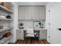 Well-lit home office with floating shelves, upper cabinets, stylish desk, and wood floors at 1461 Whistle Way, Westfield, IN 46074