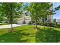 Landscaped front yard with green grass and two shade trees accentuating the two-story home at 15813 Arthur Jacob Ln, Noblesville, IN 46060