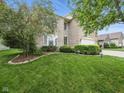 Charming two-story brick home with a well-maintained lawn and manicured landscaping at 1680 Woodfield Dr, Greenwood, IN 46143