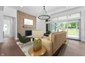 Bright living room with fireplace, hardwood floors, modern lighting, and sliding glass doors at 19832 Chatsworth Blvd, Westfield, IN 46074