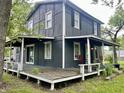 Two-story house featuring a covered porch, peeling paint and overgrown landscaping at 3190 S Tacoma Ave, Indianapolis, IN 46237