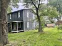 Side view of a two-story house featuring a covered porch and an outbuilding in the back yard at 3190 S Tacoma Ave, Indianapolis, IN 46237