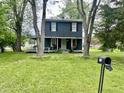 Two story home framed by mature trees with a green lawn and mailbox in the foreground at 3190 S Tacoma Ave, Indianapolis, IN 46237
