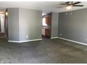 Spacious carpeted living room featuring neutral gray paint, ceiling fan, and easy access to the kitchen at 3929 Roundwood Dr, Indianapolis, IN 46235