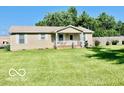 A cozy single-story home with a well-manicured lawn and a quaint covered front porch at 409 N Kyle St, Edinburgh, IN 46124