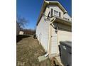 Side view of the home showcasing vinyl siding, and an attached two-car garage at 4408 Vestry Pl, Indianapolis, IN 46237