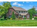 Stately brick home with lush green lawn, mature trees, and charming curb appeal at 4704 Pearcrest Way, Greenwood, IN 46143