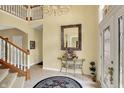 Inviting two-story foyer features tiled floor and elegant chandelier lighting at 4704 Pearcrest Way, Greenwood, IN 46143